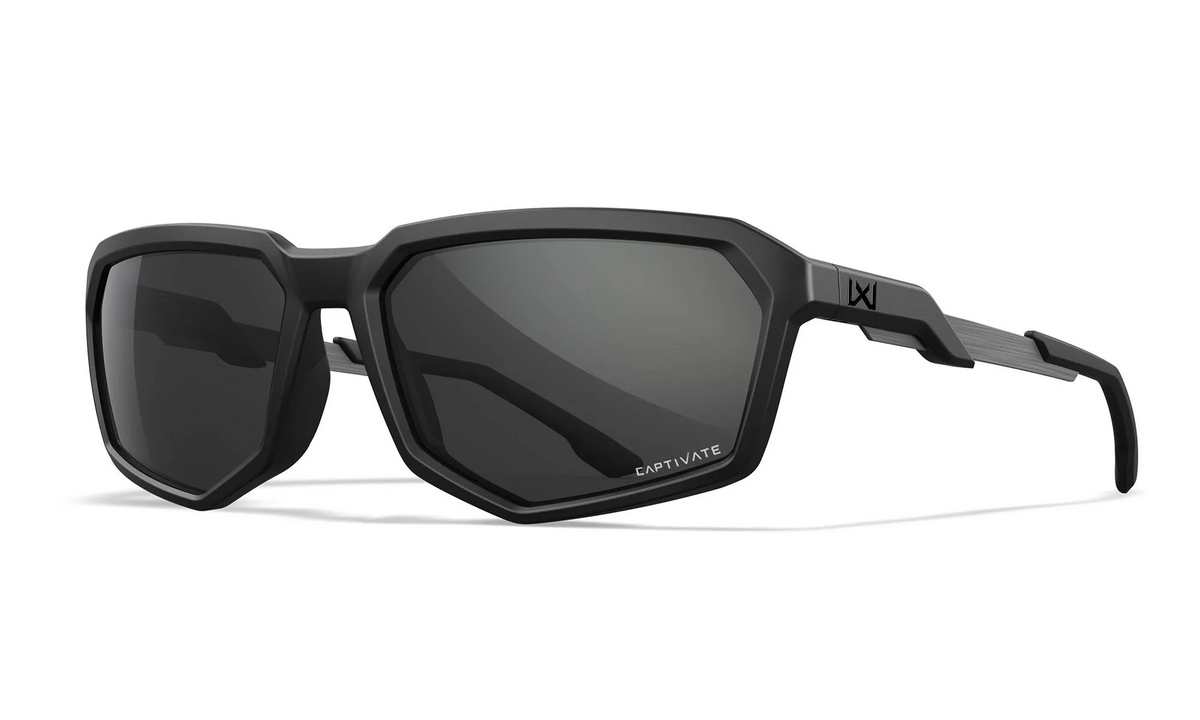 Eine mattschwarze, geometrisch geformte Sonnenbrille Wiley X Sonnenbrille RECON mit dunklen Gläsern und dickem Rahmen, mit dem WILEY X-Logo auf dem Bügel.