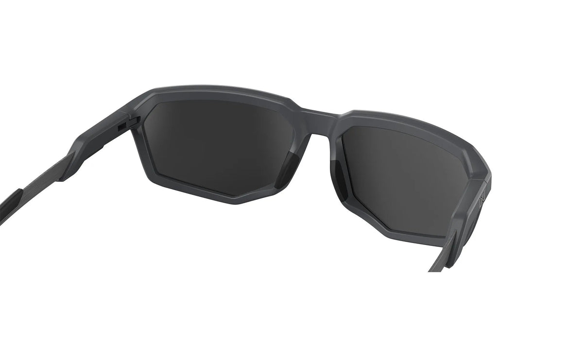 Nahaufnahme der Sonnenbrille WILEY X Wiley X Sonnenbrille RECON mit schwarzem eckigen Rahmen und dunklen Gläsern, von hinten betrachtet, um die Innenseite der Bügel und des Rahmens vor einem weißen Hintergrund zu zeigen.