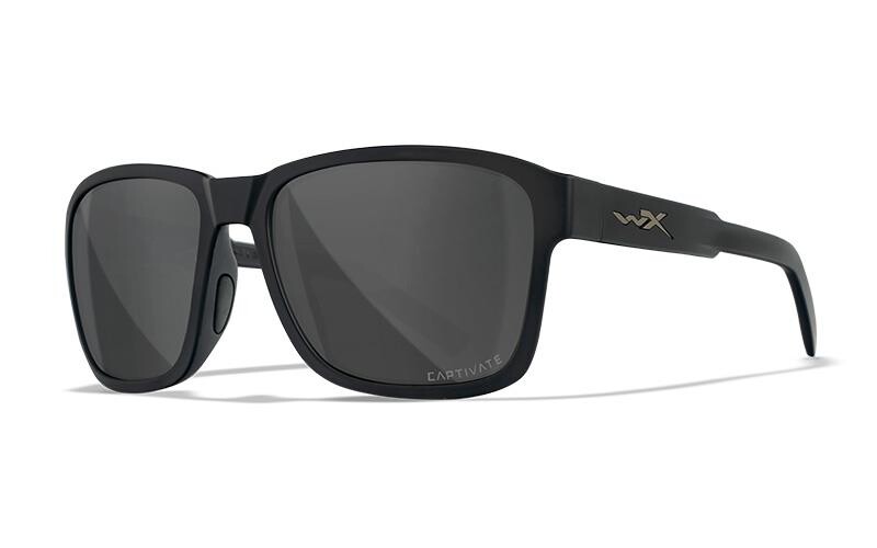 Die Wiley X Sonnenbrille TREK von WILEY X ist eine schwarze, rechteckige Sonnenbrille mit mattem Finish, dunklen, polarisierten Gläsern mit der Aufschrift CAPTIVATE und silbernen wX-Logos an den Bügeln.