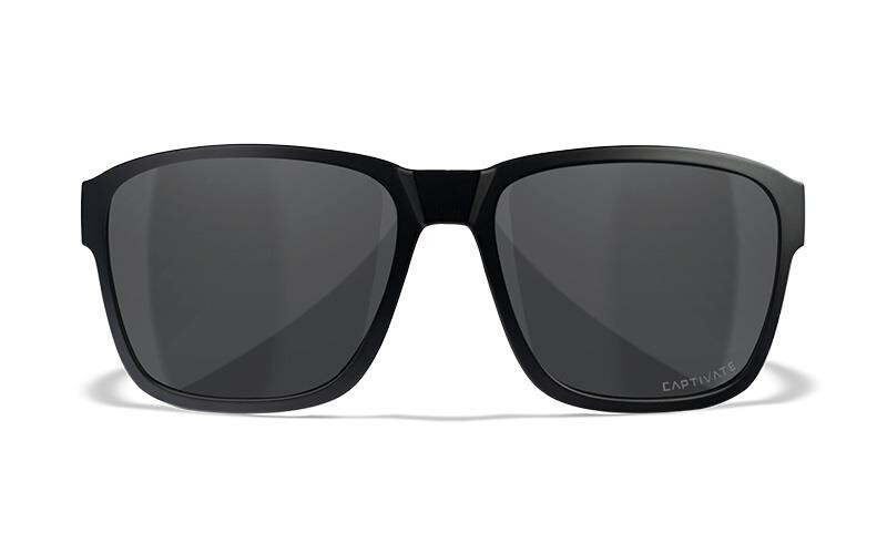 Ein Paar schwarze rechteckige WILEY X Sonnenbrille TREK mit dunklen CAPTIVATE-Gläsern, die von vorne auf einem weißen Hintergrund abgebildet sind. Das Wort CAPTIVATE ist am unteren Rand des rechten Glases schwach sichtbar.