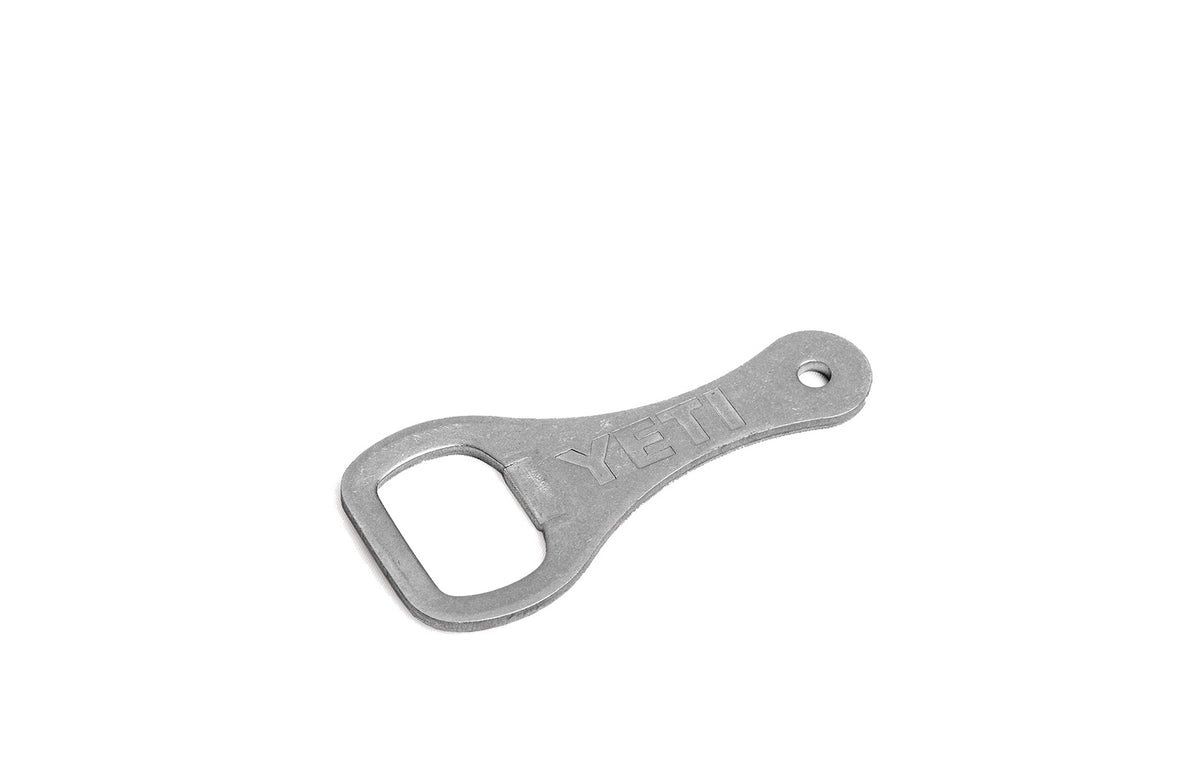 Der YETI® - Flaschenöffner von YETI verfügt über ein eingraviertes Logo, einen Metallkörper und ist ideal für Kühlboxen oder für die Wandmontage aus Edelstahl geeignet - hier auf weißem Hintergrund.