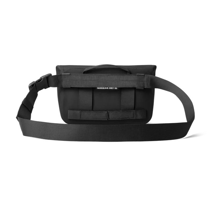 Die YETI® Sideclick® Gurt in Schwarz ist eine rechteckige Gürteltasche aus strapazierfähigem Nylon mit einem verstellbaren Riemen, einem kleinen Griff an der Oberseite und einem dezenten weißen YETI-Logo auf der Vorderseite.