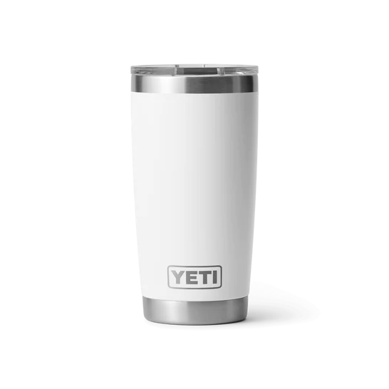Ein YETI® Becher Rambler 20 Oz in Weiß mit klarem Deckel steht aufrecht auf einem hellen Hintergrund, das YETI-Logo ist in der Nähe des Bodens sichtbar.