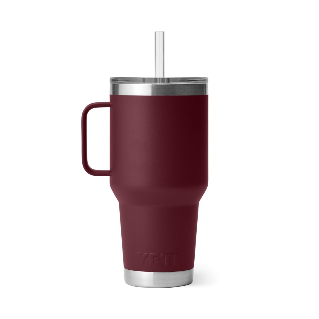 Der YETI® Rambler 35 Oz Straw Mug in Wild Vine Red ist ein isolierter Reisebecher mit Henkel, durchsichtigem Deckel, geradem Strohhalm und einem Edelstahlrand und -boden mit "YETI"-Prägung am Boden.