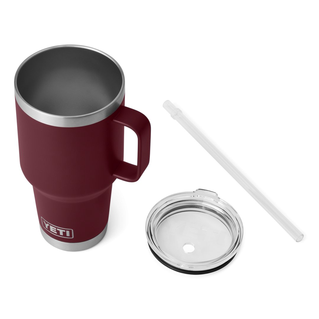 Ein YETI® Becher Rambler 35 Oz Straw Mug in Wild Vine Red wird mit einem durchsichtigen Deckel und einem wiederverwendbaren Strohhalm von YETI vor einem weißen Hintergrund präsentiert.