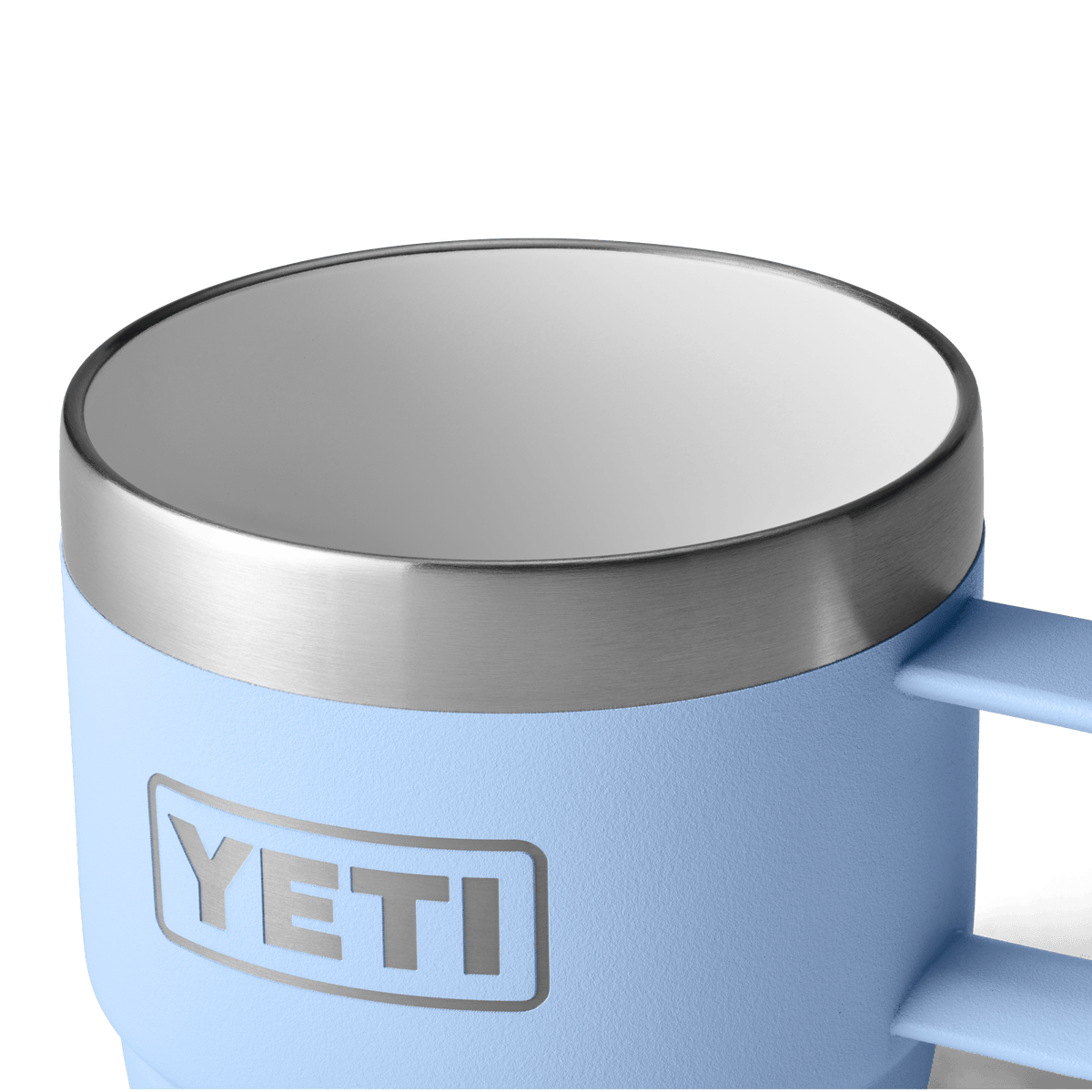 Eine Nahaufnahme des YETI® Espresso-Tasse Rambler 6 Oz (2er Pack) in Big Sky Blue, mit Edelstahlrand, Griff und einem Teil des Logos. Doppelwandige Vakuumisolierung hält Getränke heiß oder kalt. Vor weißem Hintergrund fotografiert.