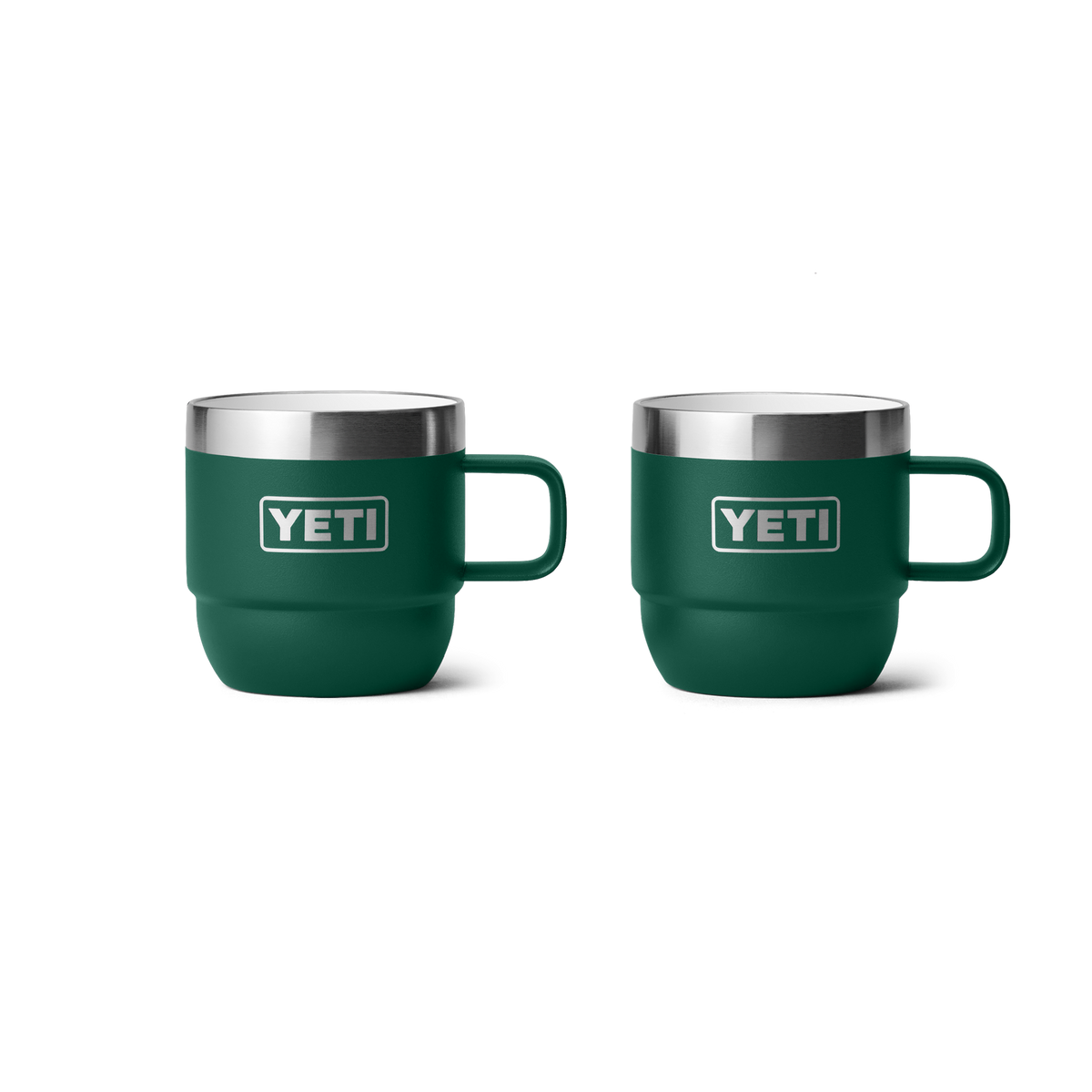 Zwei YETI® Rambler 6 Oz Espresso-Tassen (2er Pack) in Black Forest Green mit Griffen, doppelwandiger Vakuumisolierung, Edelstahlrand und YETI-Logo sind nebeneinander auf weißem Hintergrund zu sehen.