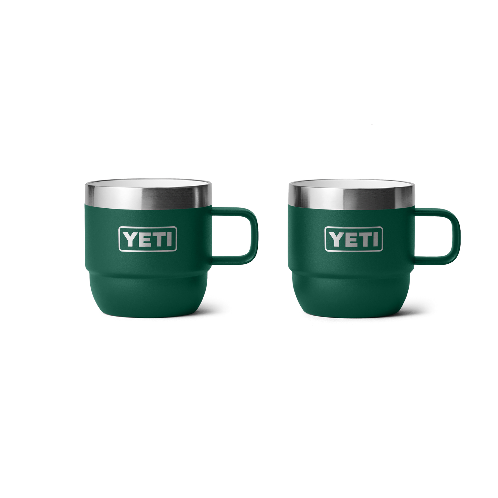 Zwei YETI® Rambler 6 Oz Espresso-Tassen (2er Pack) in Black Forest Green mit Griffen, doppelwandiger Vakuumisolierung, Edelstahlrand und YETI-Logo sind nebeneinander auf weißem Hintergrund zu sehen.