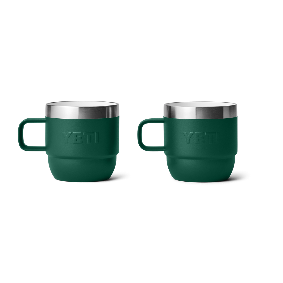 Zwei YETI® Espresso-Tasse Rambler 6 Oz (2er Pack) in Black Forest Green mit doppelwandiger Vakuumisolierung, silbernen Rändern, Griffen und geprägten YETI-Logos stehen nebeneinander auf einem schlichten weißen Hintergrund.