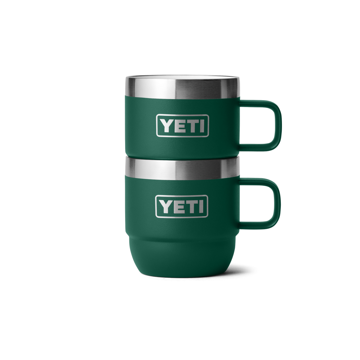 Zwei YETI® Espresso-Tassen Rambler 6 Oz (2er Pack) in Black Forest Green mit Henkel und YETI-Logo stehen stapelbar vor weißem Hintergrund. Die doppelwandig vakuumisolierten Becher der Marke YETI sind grün.