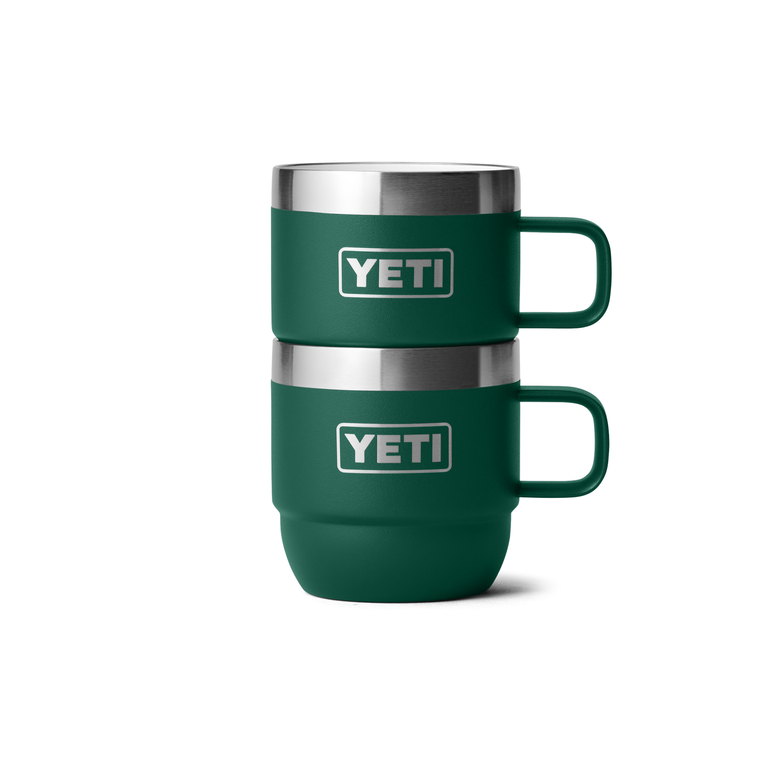 Zwei YETI® Espresso-Tassen Rambler 6 Oz (2er Pack) in Black Forest Green mit Henkel und YETI-Logo stehen stapelbar vor weißem Hintergrund. Die doppelwandig vakuumisolierten Becher der Marke YETI sind grün.