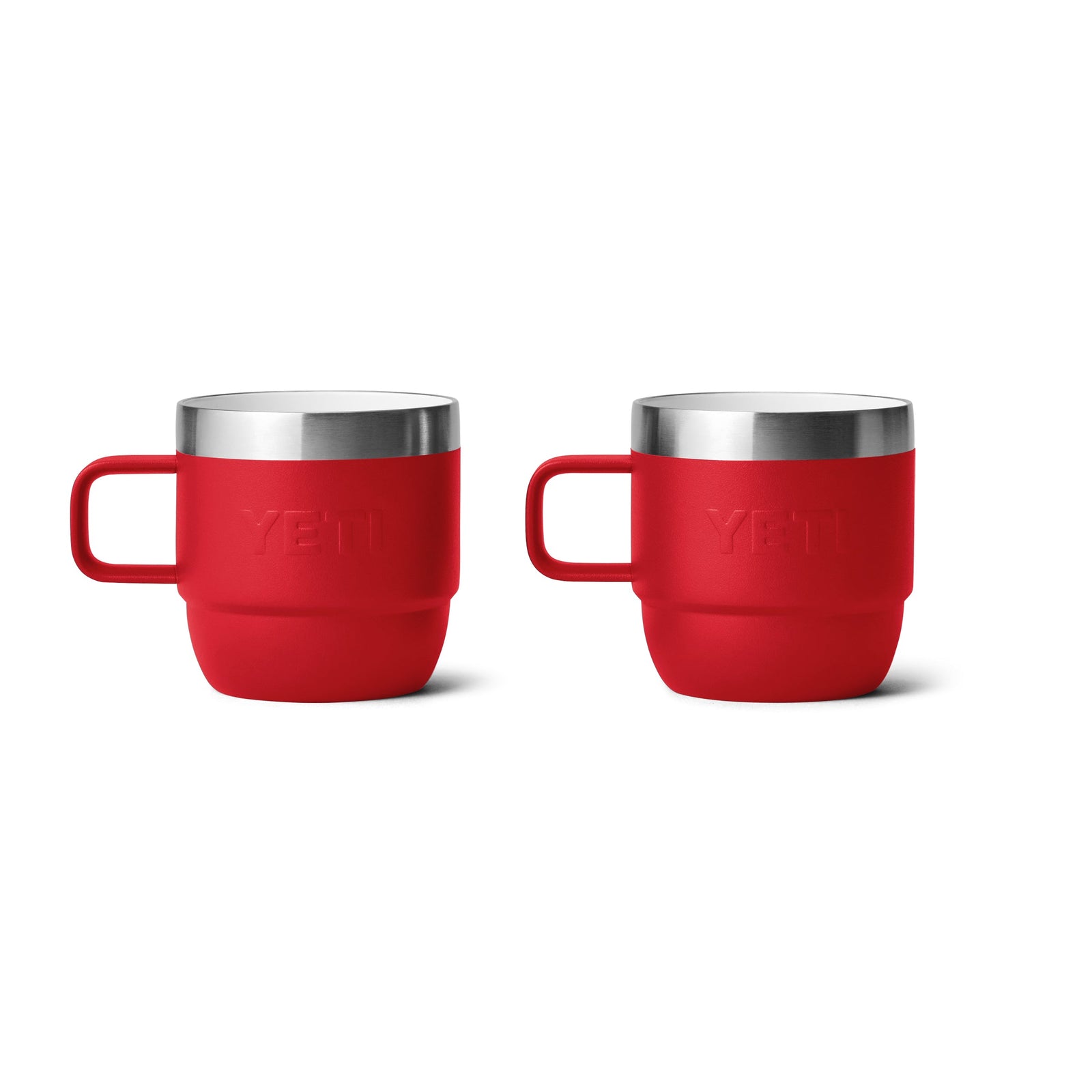 Zwei YETI® Espresso-Tasse Rambler 6 Oz Becher in Rescue Red, jeweils mit Edelstahlrand und linksseitigem Henkel, sind nebeneinander auf weißem Hintergrund platziert, was ihre doppelwandige Vakuumisolierung für beste Temperaturhaltung hervorhebt.