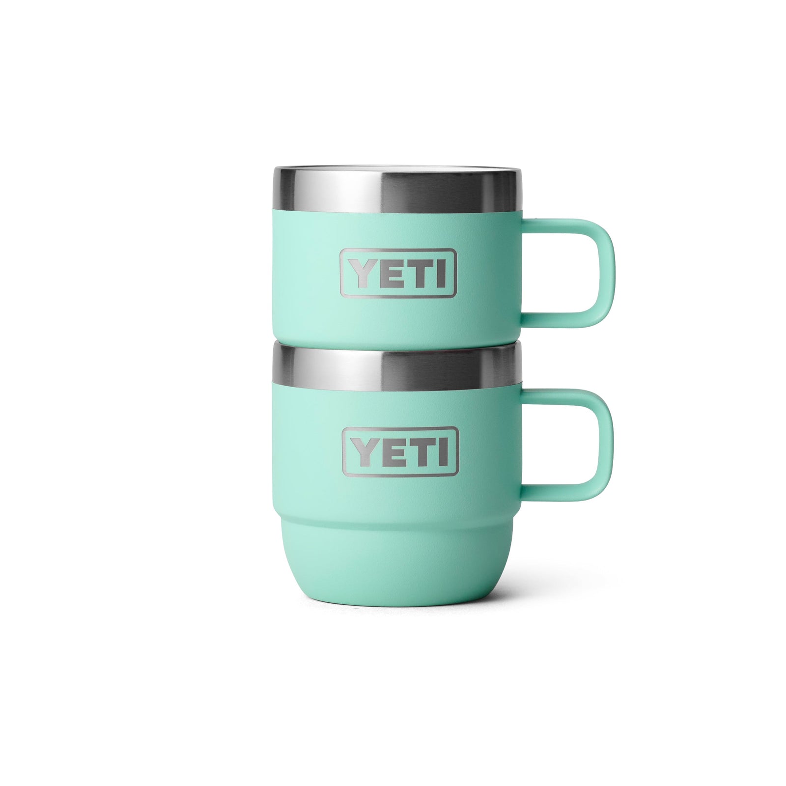 Zwei YETI® Espresso-Tassen Rambler 6 Oz (2er Pack) in Seafoam sind vor einem weißen Hintergrund gestapelt. Jeder Becher, mit silbernem Rand und Griff, verfügt über das YETI-Logo und doppelwandige Vakuumisolierung für Temperaturerhaltung.
