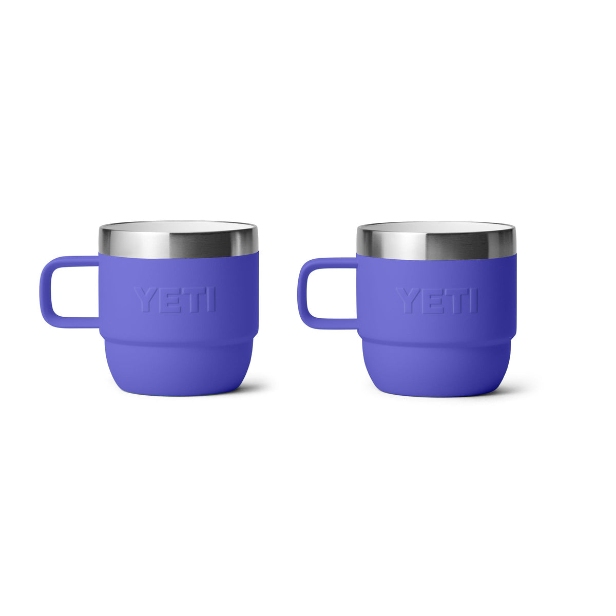 Zwei ultramarinblaue YETI® Espresso-Tasse Rambler 6 Oz Becher (2er Pack) mit Griffen und Edelstahlrändern sind nebeneinander abgebildet und verfügen über eine doppelwandige Vakuumisolierung. Jeder Becher zeigt das geprägte YETI-Logo auf der Vorderseite.