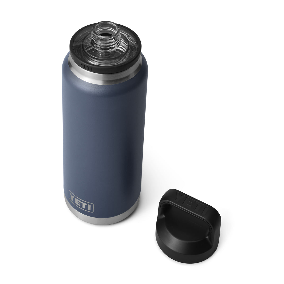 Die YETI® Flasche Rambler 36 Oz - Navy von YETI mit Edelstahl-Akzenten wird auf weißem Hintergrund gezeigt, der schwarze Deckel ist entfernt und der Chug Cap aufgesetzt.