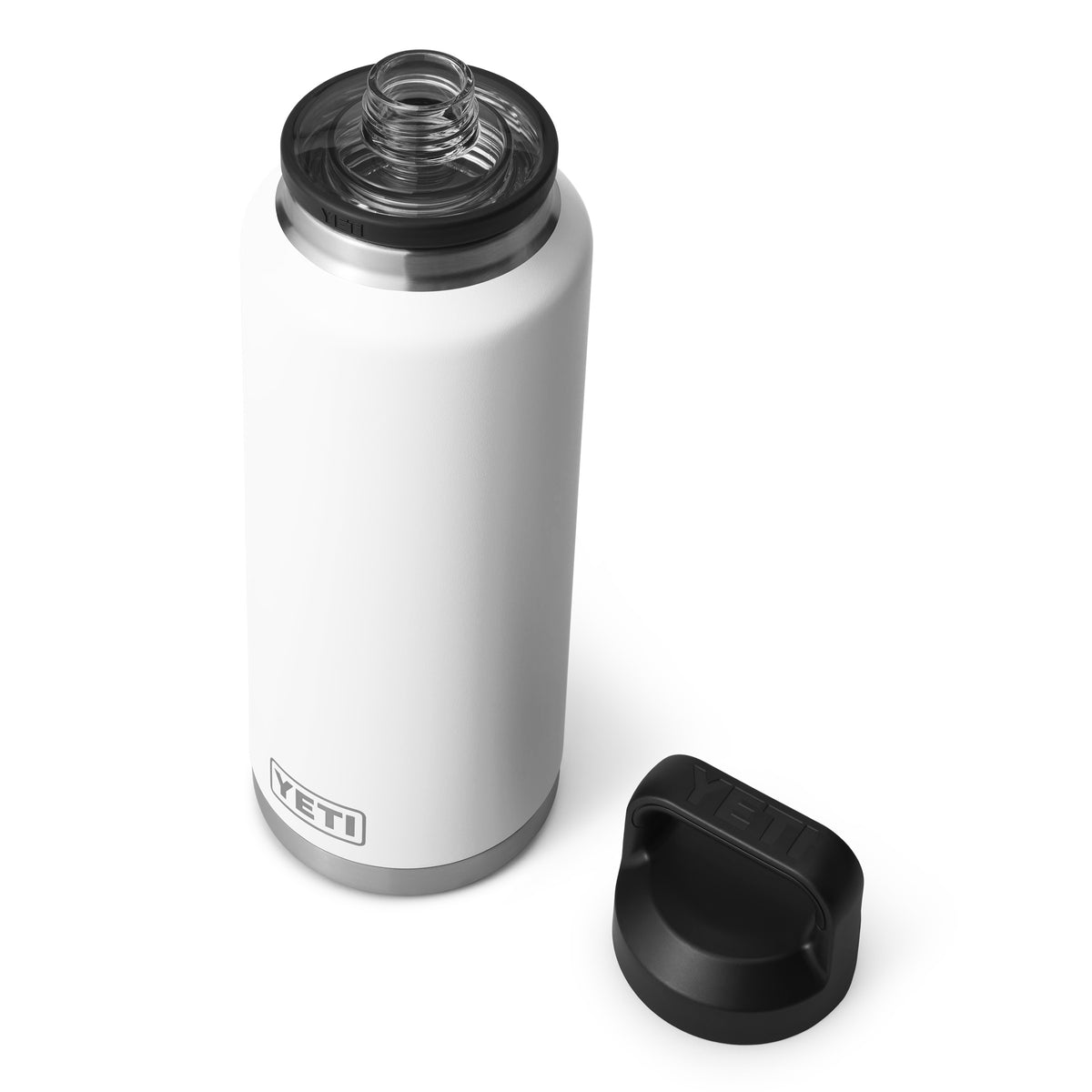 Die YETI® Flasche Rambler 46 OZ - White aus 18/8 Edelstahl mit doppelwandiger Vakuumisolierung steht aufrecht vor weißem Hintergrund, der schwarze Schraubdeckel liegt daneben und die Flaschenöffnung ist sichtbar.