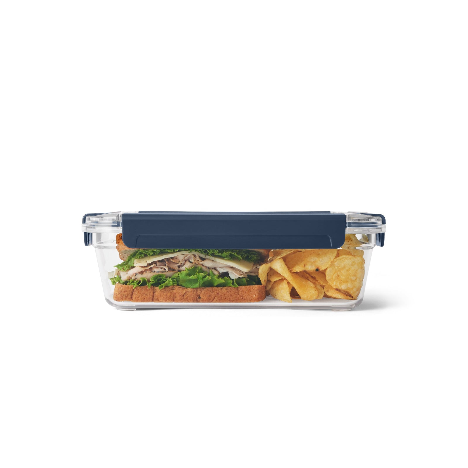 Die YETI® Food Storage Large von YETI ist ein durchsichtiger, rechteckiger Behälter mit einem marineblauen Deckel, in dem ein Sandwich und Chips Platz finden. Diese BPA-freie Dose ist ideal für die Aufbewahrung von Lebensmitteln unterwegs, abgebildet auf einem schlichten weißen Hintergrund.