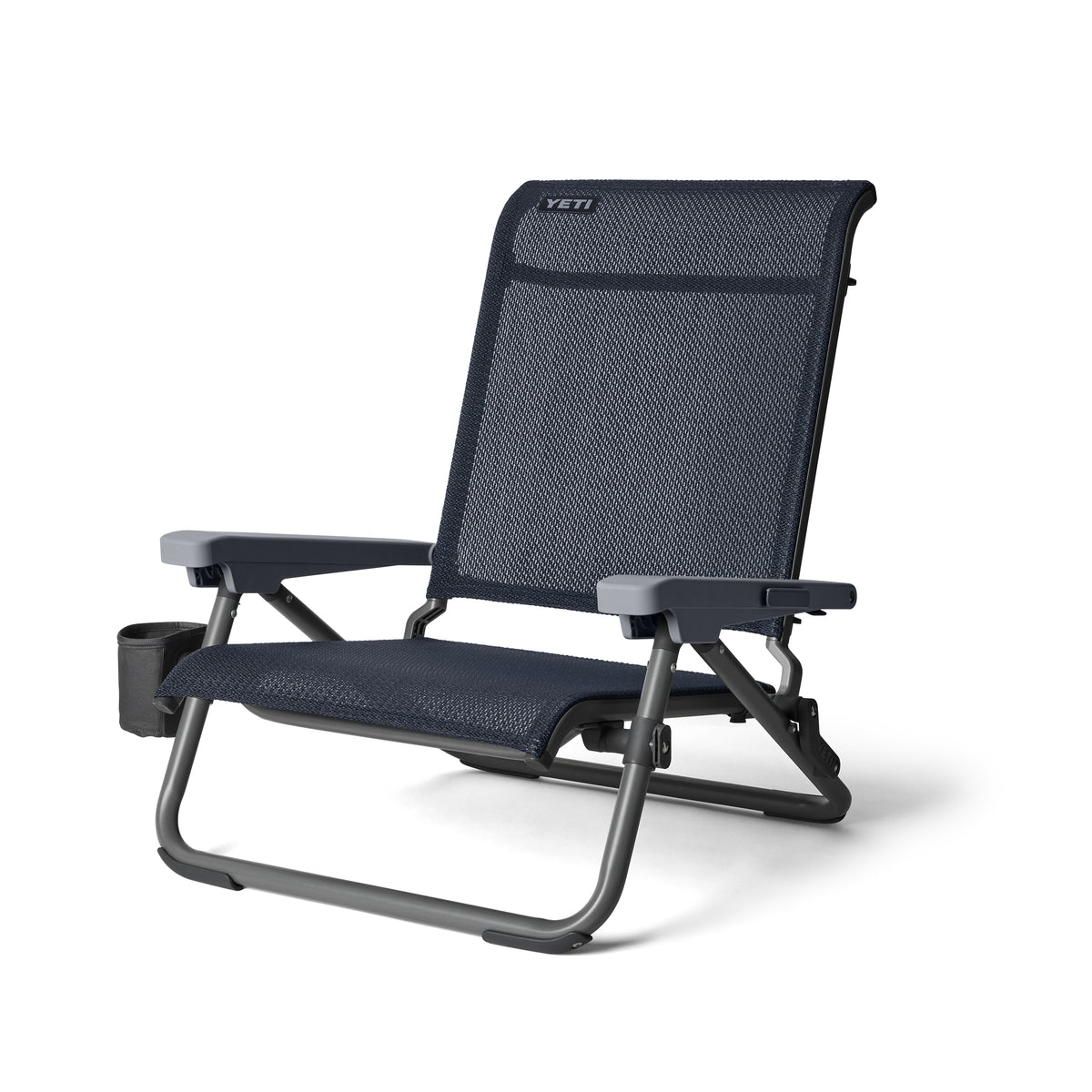 Der YETI® Hondo Beach Chair - Navy hat ein dunkelblaues und schwarzes Design, einen Netzsitz und eine Rückenlehne, stabile Armlehnen, einen Becherhalter auf der linken Seite und das YETI-Logo auf der Oberseite - perfekt für stilvolles Faulenzen im Freien.