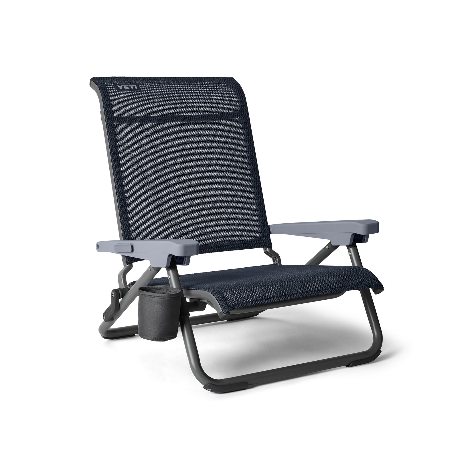 Der YETI® Hondo Beach Chair - Navy hat ein marineblaues und graues Design, einen Sitz und eine Rückenlehne aus Netzgewebe, einen stabilen Metallrahmen, Armlehnen, einen Becherhalter auf der linken Seite und ein YETI-Branding auf der oberen Rückenlehne.