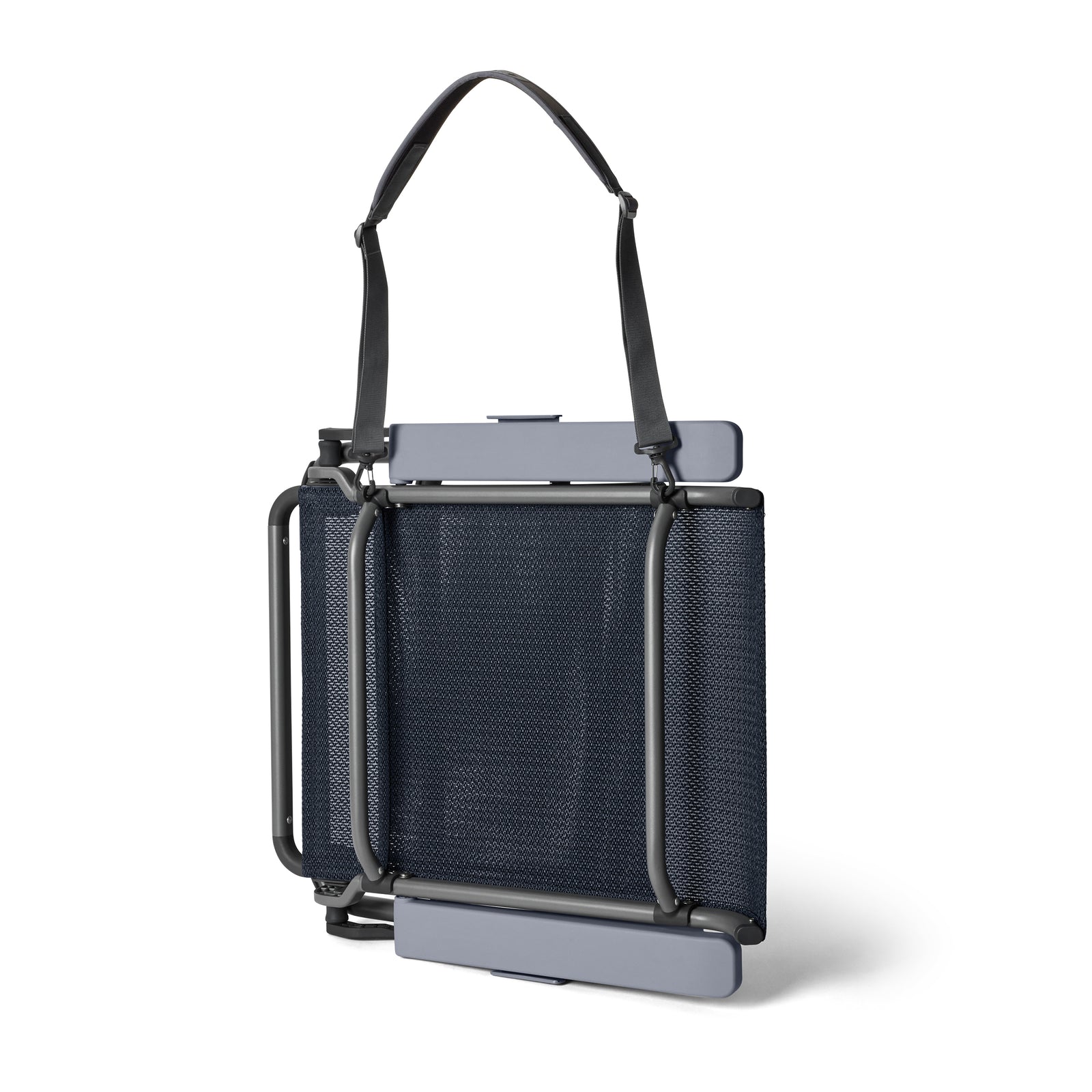 Der gefaltete YETI® Hondo Beach Chair - Navy mit Sitz und Rückenlehne aus Netzgewebe, schwarzem Metallrahmen und verstellbarem Tragegurt steht aufrecht auf weißem Hintergrund.