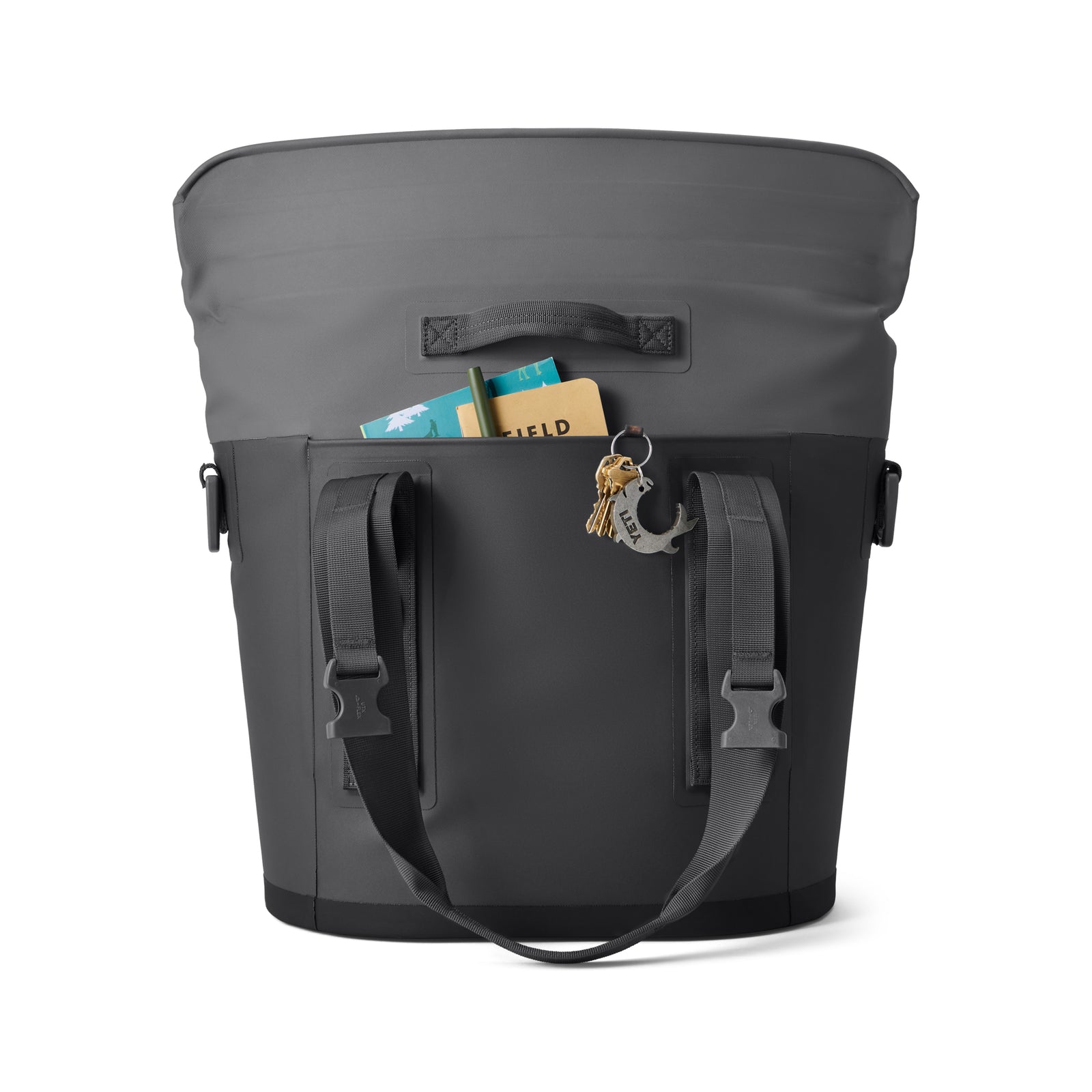 Die YETI® Hopper M15 Soft Cooler in Charcoal ist eine schwarz-graue Soft-Side-Tasche mit Schulterriemen, Griff und Anker-Schlüsselanhänger - ideal, um Gegenstände kühl zu halten. Die Vordertasche bietet Platz für ein Notizbuch und ein Buch und zeigt den typischen YETI-Stil.