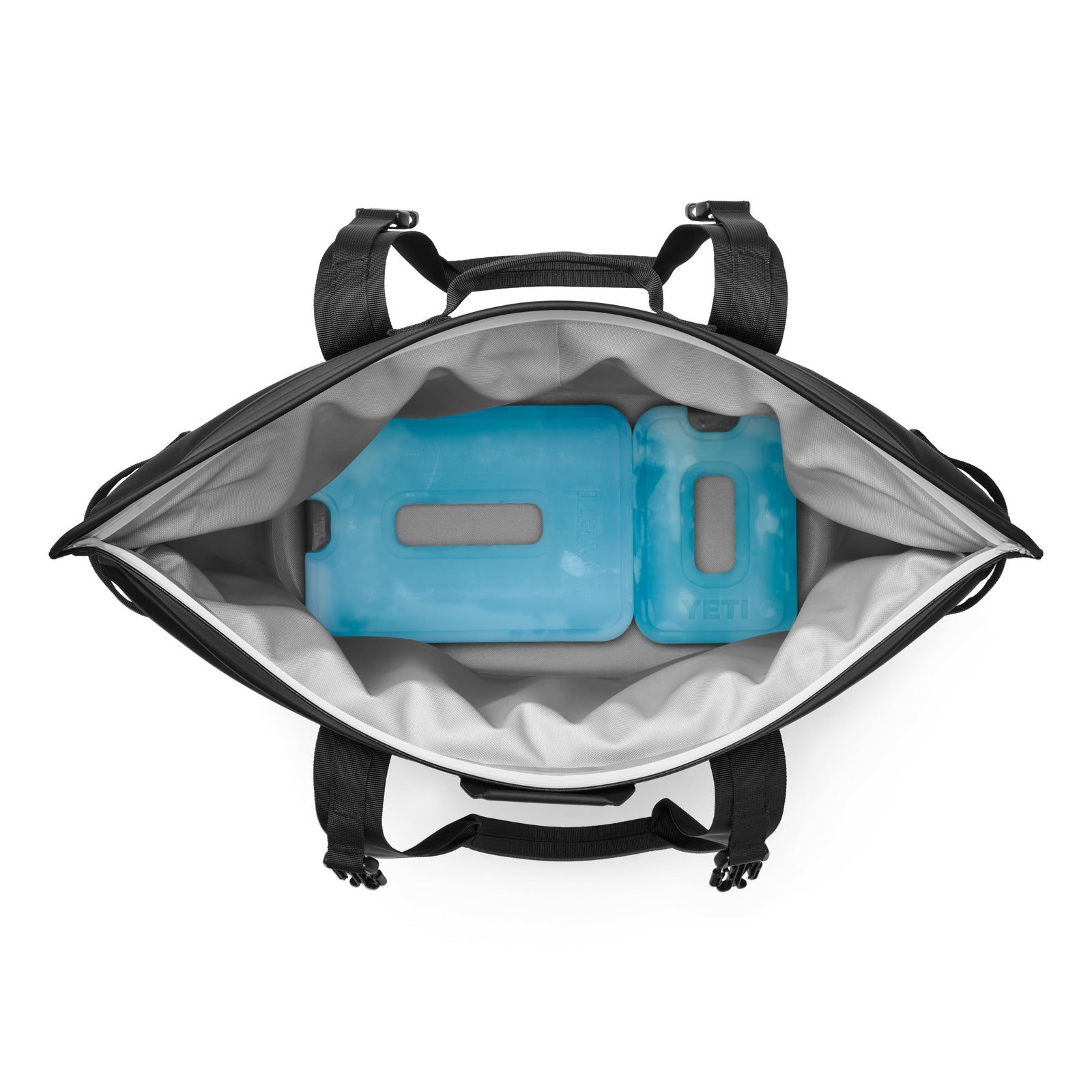 Draufsicht auf den YETI® Hopper M30 Soft Cooler in Schwarz von YETI mit schwarzen Griffen und zwei blauen, rechteckigen Kühlakkus im Inneren - damit Sie Ihre Sachen unterwegs kühlen und organisieren können.