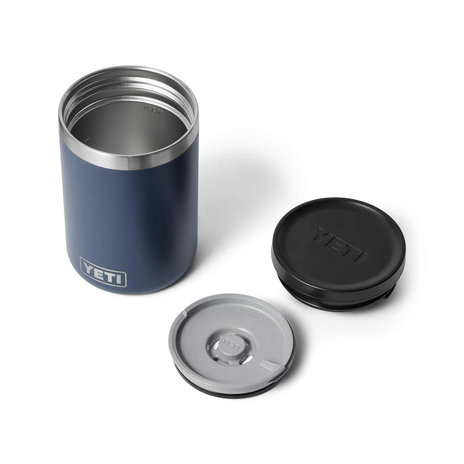 Ein navyfarbener YETI® Isolierter Essensbehälter Rambler 16 oz wird auf einer weißen Oberfläche mit zwei abnehmbaren Deckeln - einem schwarzen und einem durchsichtigen mit grauem Rand - präsentiert, die beide das YETI-Logo zeigen und eine vakuumisolierte 18/8 Edelstahlkonstruktion aufweisen.
