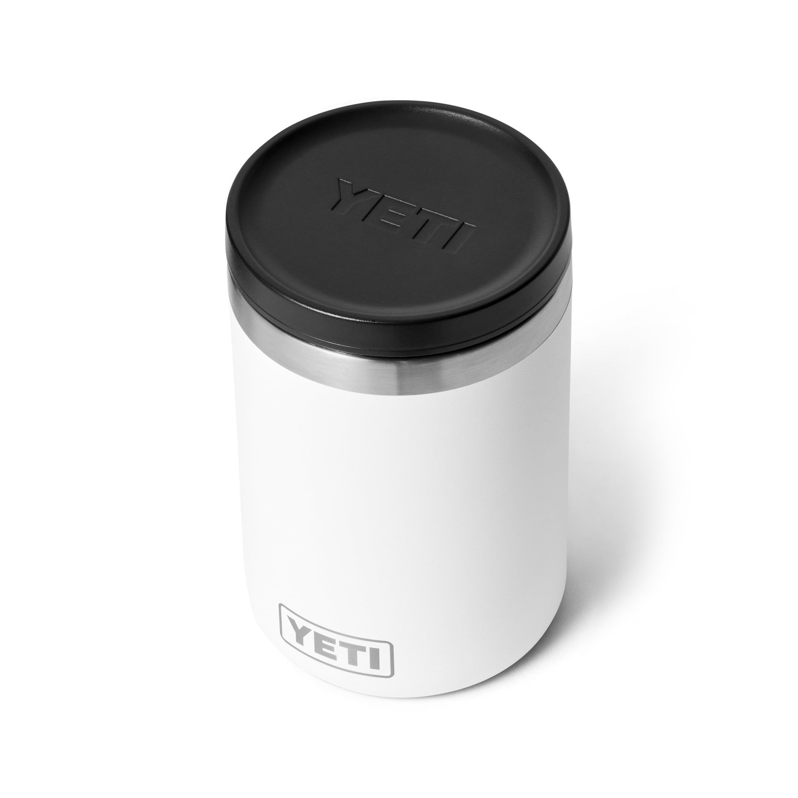 Ein weißer YETI® Isolierter Essensbehälter Rambler 16 oz ist mit einem schwarzen Deckel und einer Edelstahlverzierung auf einem weißen Hintergrund abgebildet. Das YETI-Logo erscheint sowohl auf dem Deckel als auch auf der Seite dieses isolierten Essensbehälters.