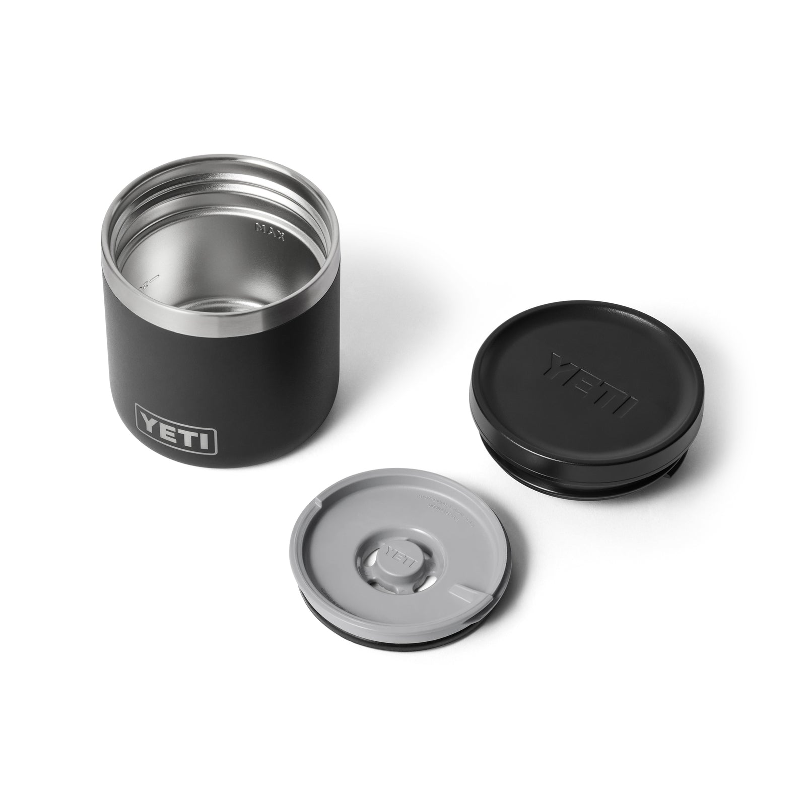 Der YETI® Isolierter Essensbehälter Rambler 8 oz - Black mit Edelstahl-Innenraum wird mit zwei abnehmbaren Deckeln, einem schwarzen und einem grauen, auf einer weißen Oberfläche präsentiert.