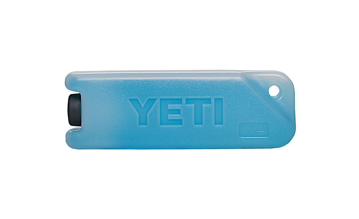 Der YETI® Kühlakku Eisblock 1 lb ist ein rechteckiger, blauer, bruchsicherer Kühlakku mit einer abgerundeten Ecke, einem kleinen Loch an einem Ende und der Prägung "YETI" auf seiner Oberfläche.