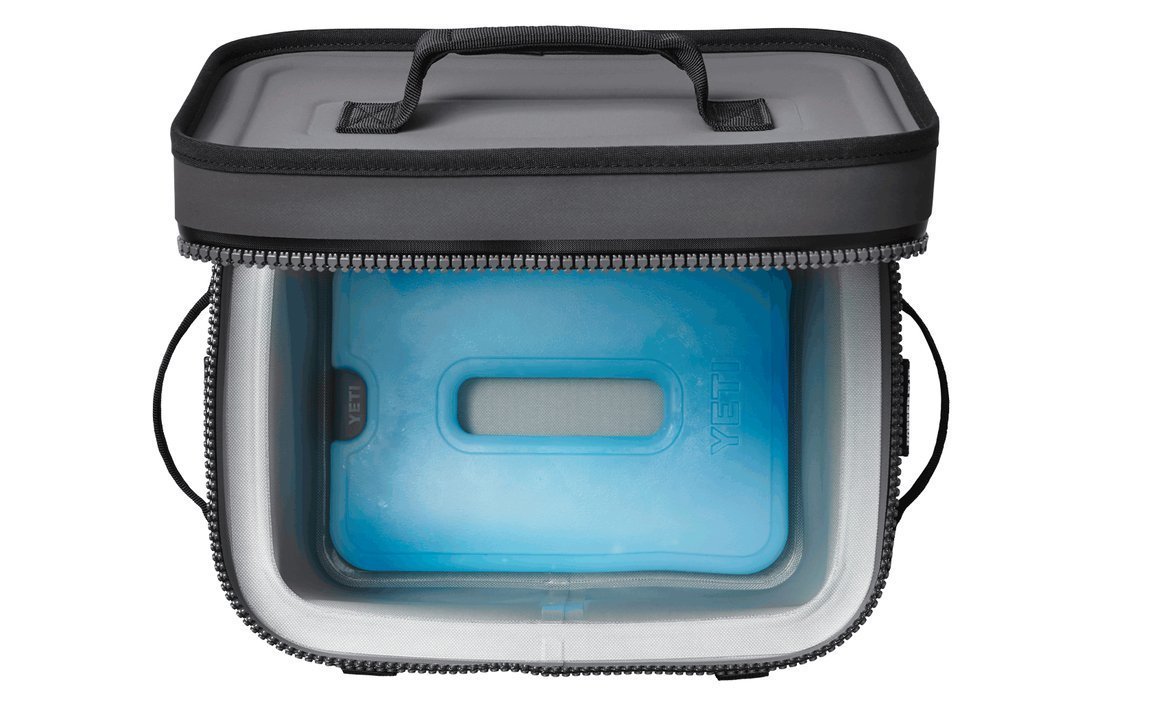 Eine Soft-Side-Kühlbox mit teilweise geöffnetem Deckel, in dem sich eine YETI® Kühlakku Ice Sheet Large von YETI befindet. Die Kühlbox verfügt über schwarze Griffe an der Oberseite und den Seiten sowie einen Reißverschluss um den Deckel für einen sicheren Verschluss.