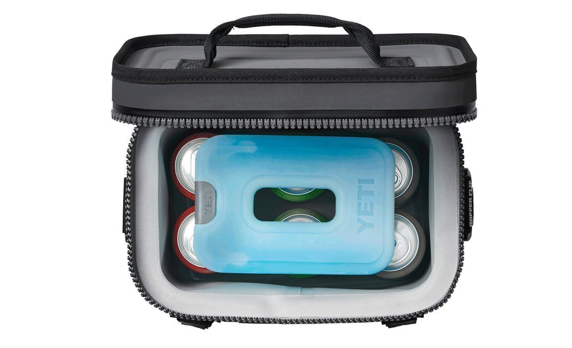 Draufsicht auf eine offene Kühltasche mit mehreren Dosen und einem YETI® Kühlakku Ice Sheet Medium, das die Getränke kalt hält.