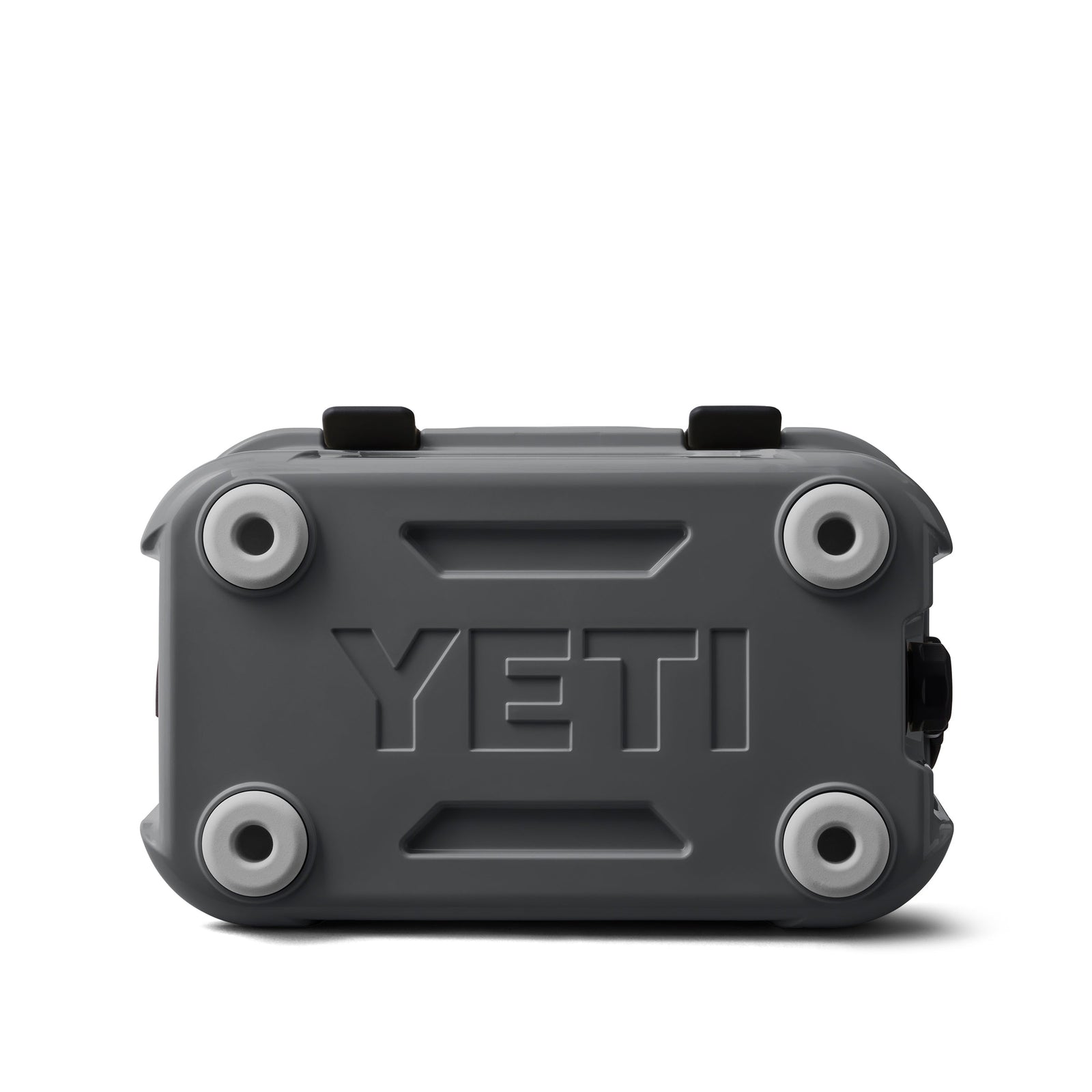 Eine anthrazitfarbene YETI® Kühlbox Roadie 15, abgebildet von unten mit vier runden Gummifüßen, erhabenen Rippen und einem mittig eingeprägten YETI-Logo.