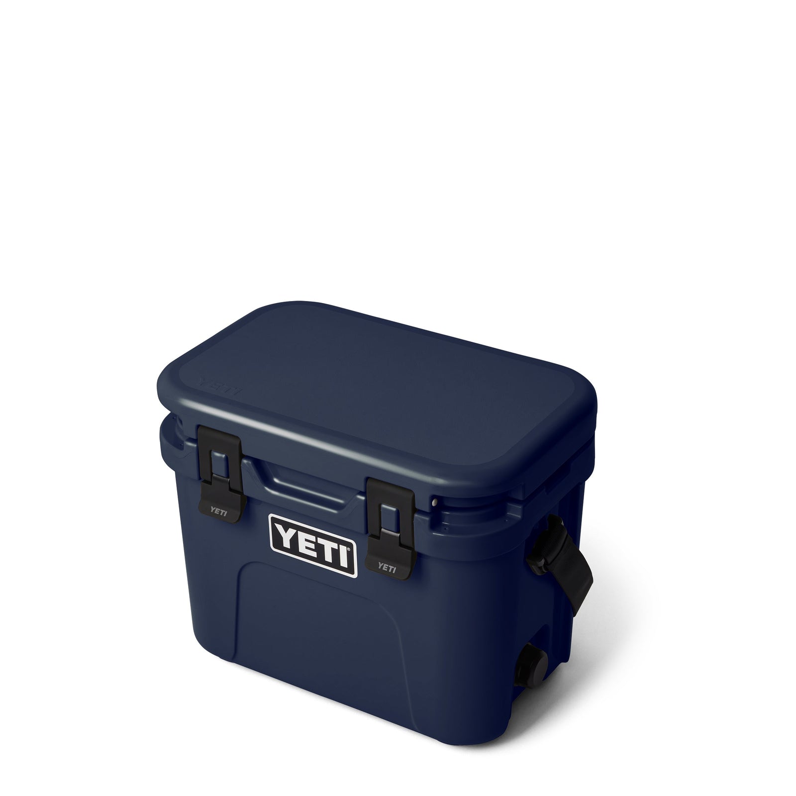 Die YETI® Kühlbox Roadie 15 in Navy mit schwarzen Verschlüssen und YETI Logo wird schräg auf weißem Hintergrund präsentiert.
