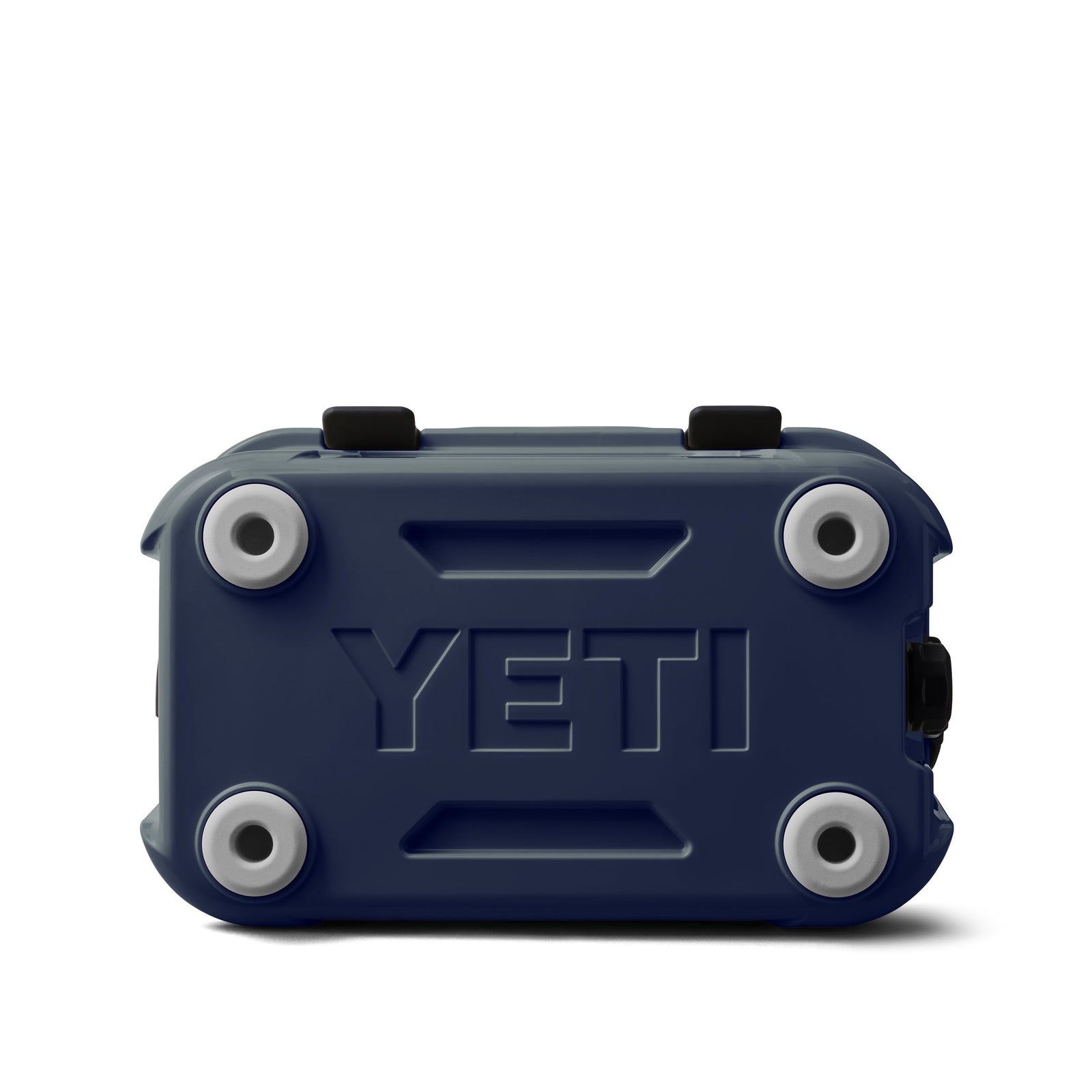 Eine YETI® Kühlbox Roadie 15 - Navy von YETI ist auf der Rückseite abgebildet, die den Boden mit vier runden grauen rutschfesten Füßen und einem erhabenen YETI-Logo in der Mitte zeigt.