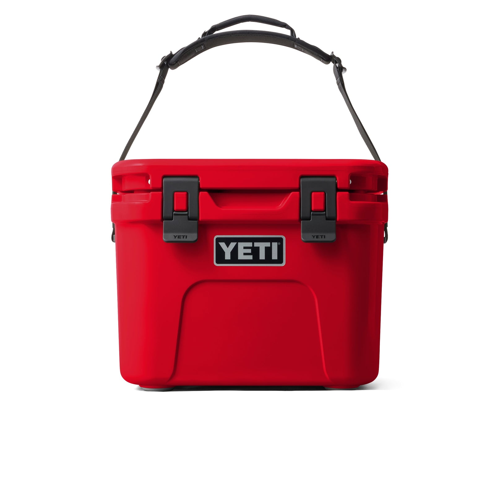 Die YETI® Kühlbox Roadie 15 in Rescue Red hat einen schwarz-grauen Tragegriff, schwarze Verschlüsse und das YETI-Logo auf der Vorderseite, das auf weißem Hintergrund zu sehen ist.