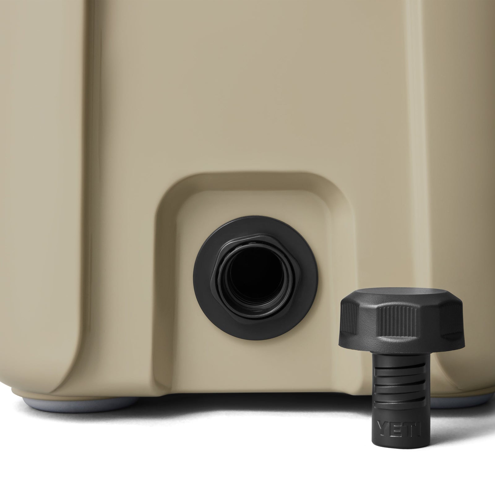 Nahaufnahme der YETI® Kühlbox Roadie 15 - Tan Ausgießer mit schwarzem Deckel mit YETI-Prägung, neben der Öffnung auf weißem Hintergrund dargestellt.