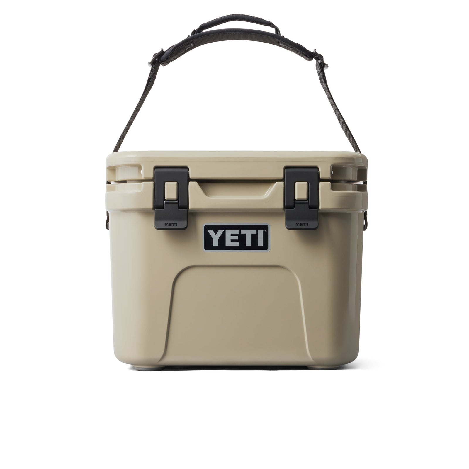 Die YETI® Kühlbox Roadie 15 in Tan mit einem stabilen Griff und zwei schwarzen Verschlüssen auf der Vorderseite ist auf einem schlichten weißen Hintergrund abgebildet.
