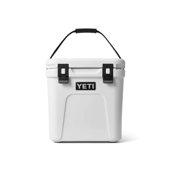 Die YETI® Kühlbox Roadie 24 in Weiß, mit schwarzem Griff und zwei schwarzen Frontverschlüssen plus PermaFrost Isolierung, wird vor einem schlichten weißen Hintergrund dargestellt.