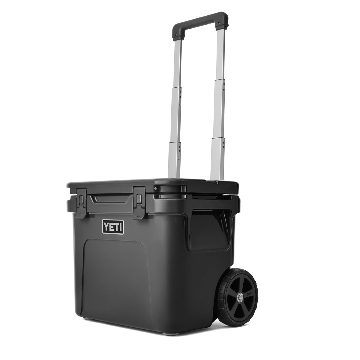 Die YETI® Kühlbox Roadie 32 - Charcoal ist eine robuste Kühlbox mit Teleskopgriff, stabilen Rädern, starken Seitenverschlüssen und dem ikonischen YETI Logo auf der Front.
