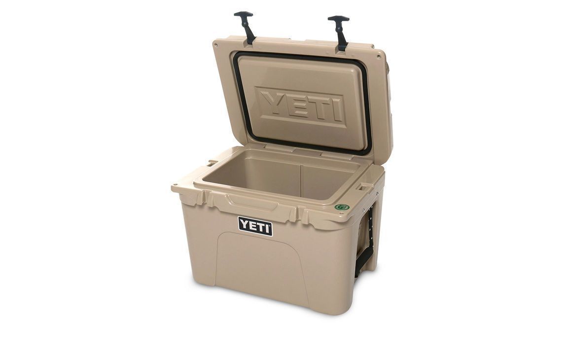 Die YETI® Kühlbox Tundra 35 - Tan von YETI besticht durch ein robustes Design mit stabilen Griffen und dicken Wänden. Ihr offener Deckel gibt den leeren, isolierten Innenraum frei - ideal für die Eisaufbewahrung und jedes Camping-Abenteuer.