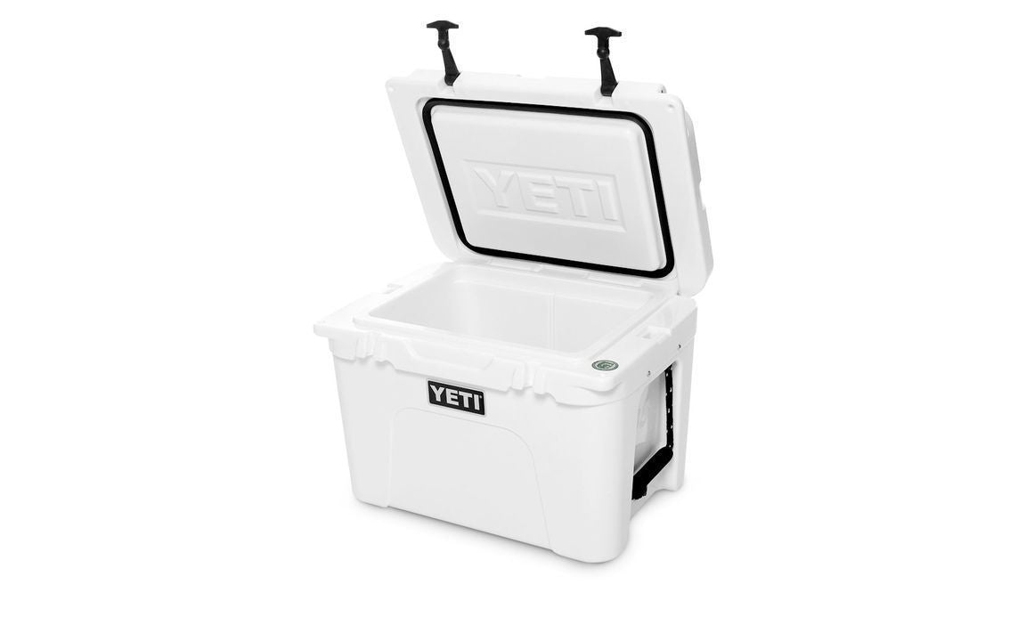 Die geöffnete YETI® Kühlbox Tundra 35 - White zeigt ihren geräumigen, robusten Innenraum. Auf der Vorderseite prangt das YETI-Logo, und zwei schwarze Verschlüsse sichern diese robuste Kühlbox - ideal für Campingausflüge.