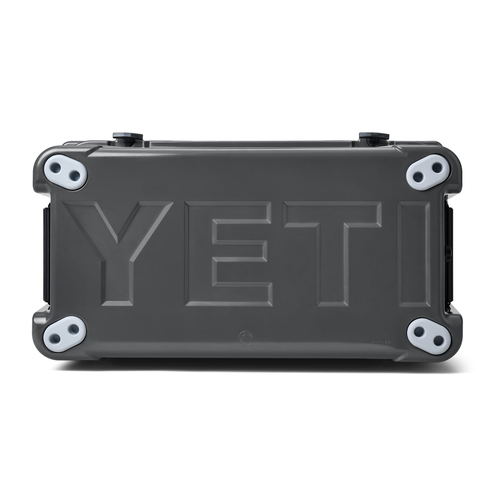 Die YETI® Kühlbox Tundra 65 - Charcoal, abgebildet von unten mit vier runden Gummifüßen und dem geprägten YETI-Logo, ist ideal für Ihr nächstes Campingabenteuer.