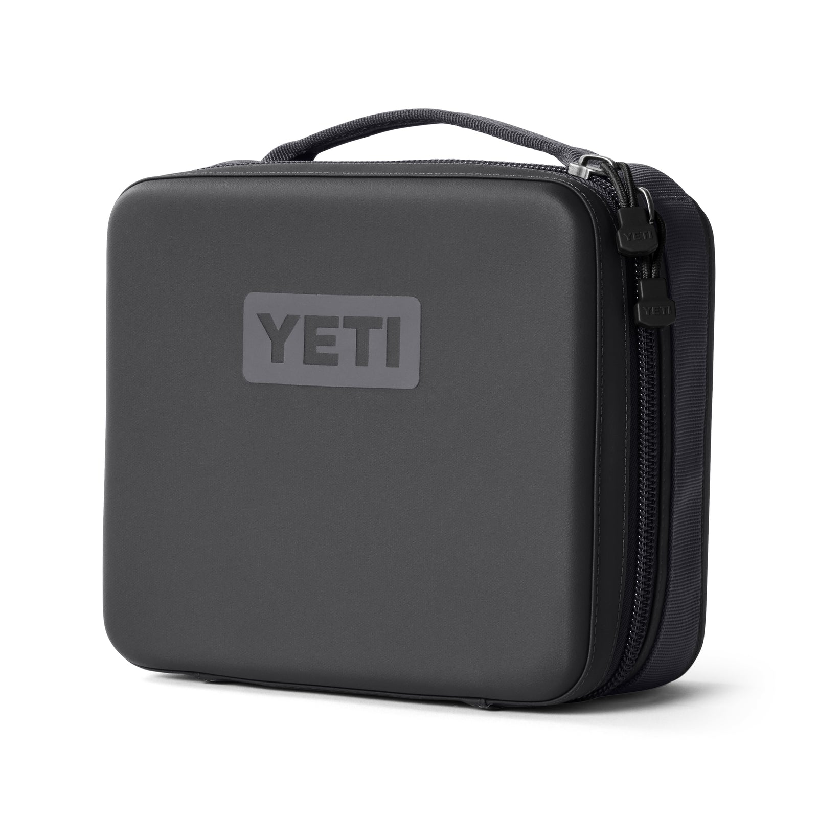 Die schwarze YETI® Kühltasche Daytrip Lunch Box 3L - Charcoal hat eine harte Schale, abgerundete Kanten, einen Reißverschluss, einen Griff an der Oberseite und ein YETI-Logo - ideal, um Ihr Mittagessen stilvoll zu transportieren.