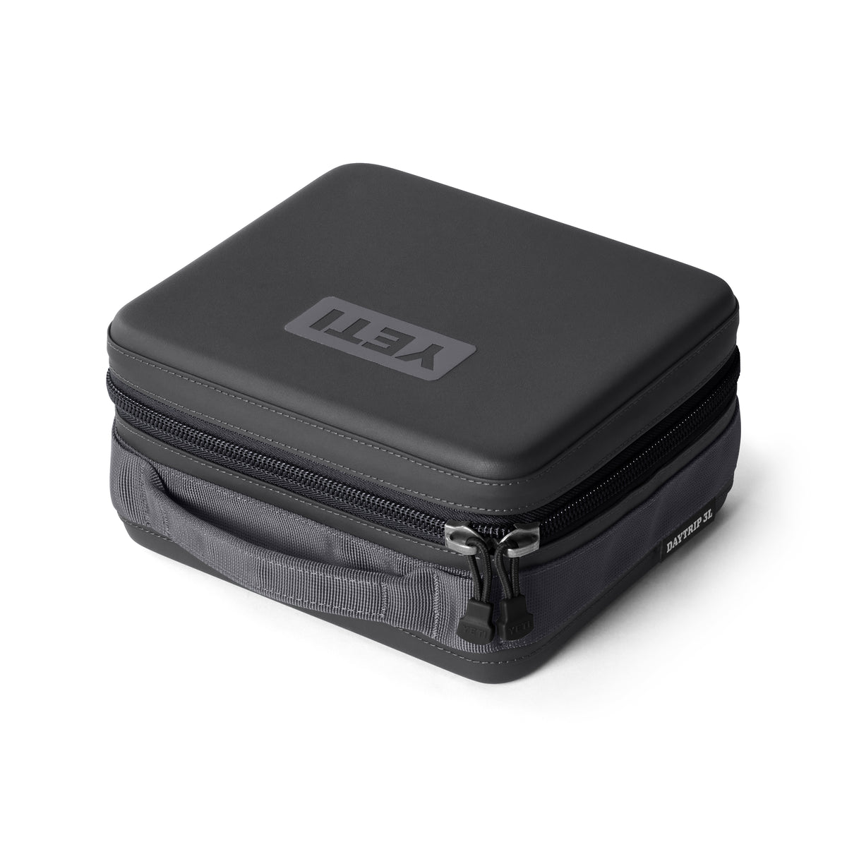 Die YETI® Kühltasche Daytrip Lunch Box 3L - Charcoal ist eine schwarze, quadratische Lunchbox mit ColdCell Flex-Isolierung, Reißverschlusstasche, robustem Äußeren und seitlichem Griff auf weißem Hintergrund.
