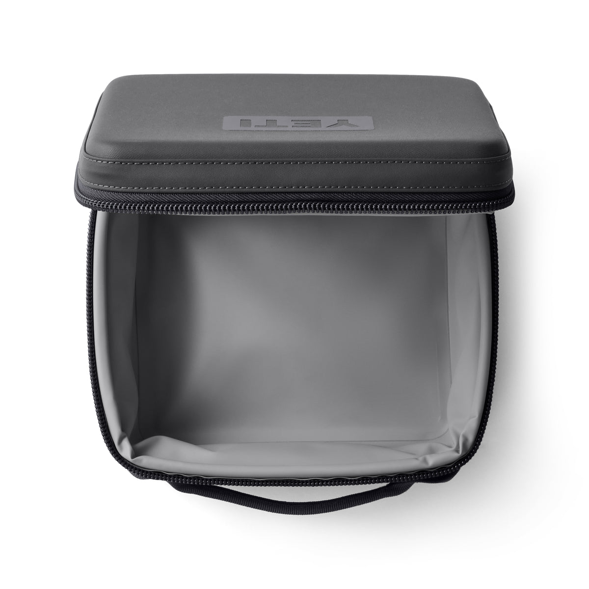 Die von oben geöffnete YETI® Kühltasche Daytrip Lunch Box 3L in Charcoal verfügt über eine graue ColdCell Flex-Isolierung im Inneren, einen Reißverschluss, einen Tragegriff und ein eingeprägtes YETI-Logo auf dem Hartschalendeckel.