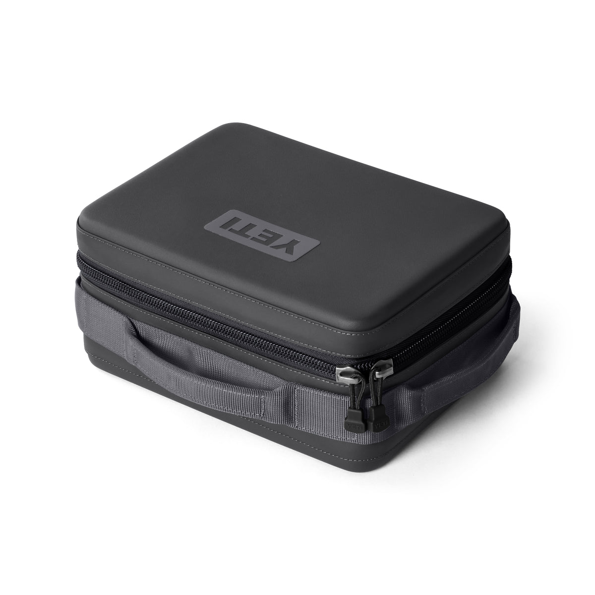 Die YETI® Kühltasche Daytrip Lunch Box 5L in Charcoal verfügt über ein Hartschalendesign, einen Reißverschluss, einen stabilen Stoffgriff, ColdCell Flex Isolierung für hervorragende Isolierung und ein YETI Logo auf der Oberseite. Abgebildet vor einem weißen Hintergrund.