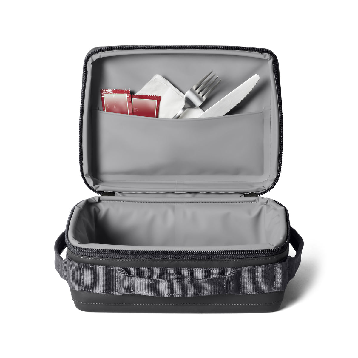 Die offene YETI® Kühltasche Daytrip Lunch Box 5L in Charcoal zeigt ihren grauen Innenraum mit ColdCell Flex Isolierung, der über dem leeren Hauptfach eine Deckeltasche für Utensilien und Gewürzpakete aufweist.