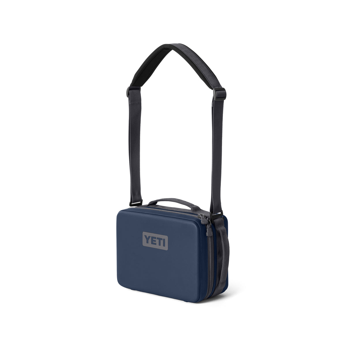 Die YETI® Kühltasche Daytrip Lunch Box 5L in navy mit rechteckiger Form, Reißverschluss und verstellbarem schwarzen Schultergurt steht aufrecht vor weißem Hintergrund.