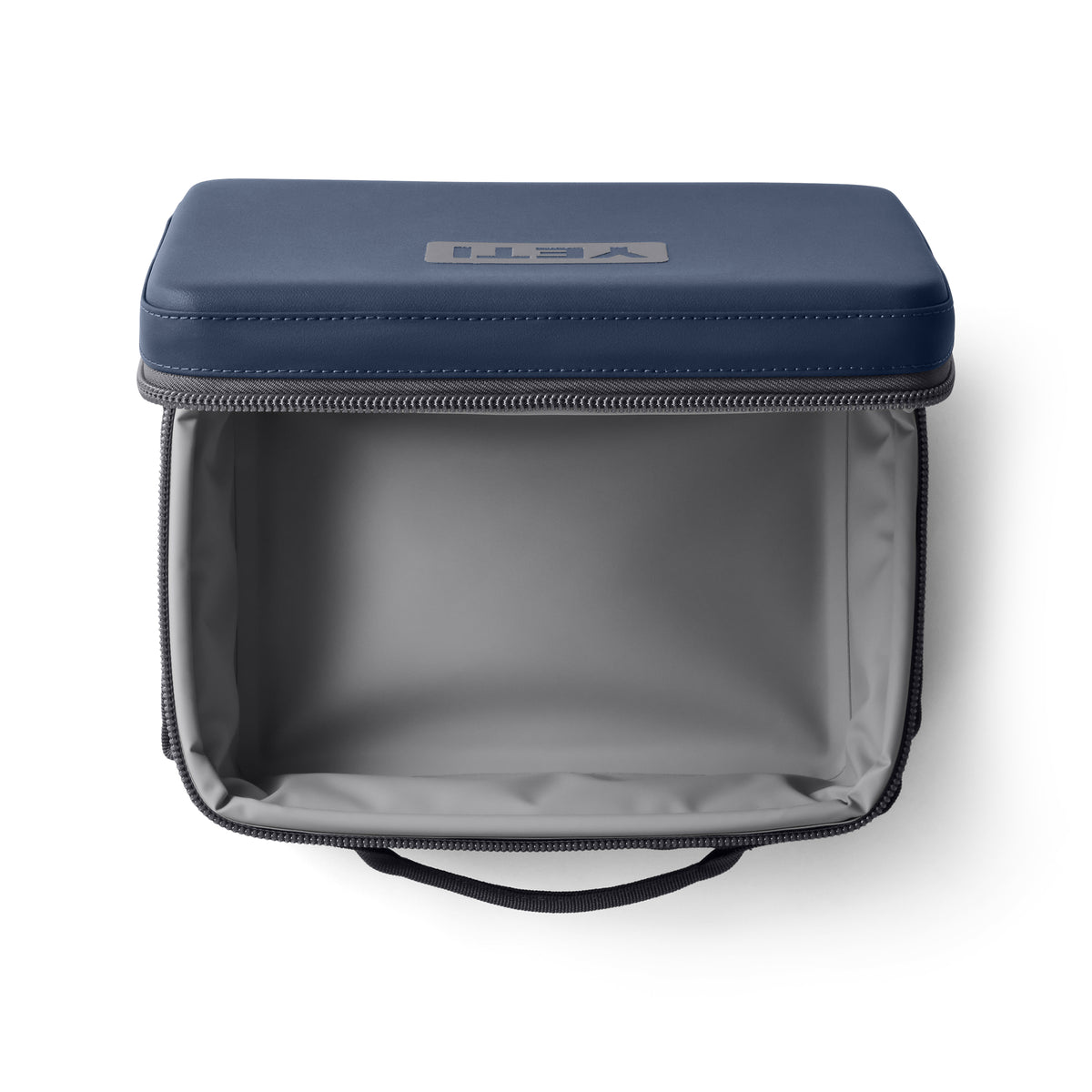 Die YETI® Kühltasche Daytrip Lunch Box 5L - Navy verfügt über einen geräumigen grauen Innenraum, einen grauen Reißverschluss, einen Tragegriff und ein YETI-Logo auf dem Deckel - perfekt als isolierte Lunch-Tasche für jeden Tag.